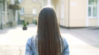 Girl walking on the street, camera behind her, she turned to it and ...