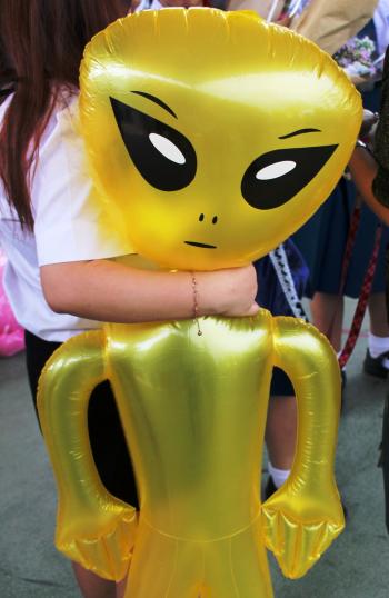 Girl holds an inflatable alien toy