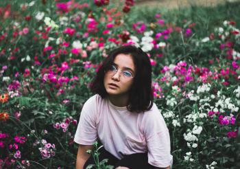 Girl in White T-shirt Surrounded by Flowers