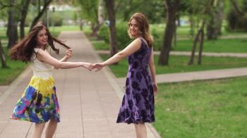 attractive girls walking through the Park and smile. girlfriends ...