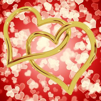 Gold Heart Shaped Rings On Red Bokeh Representing Love And Romance