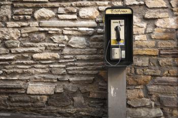 Gray and Black Telephone Booth Standing Near Gray Stone Wall at Daytime