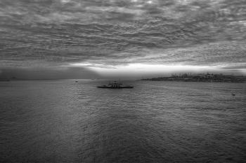 Gray Scale Photo of a Boat on Body of Water Under Cloudy Sky