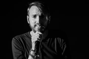 Grayscale Photo of Man Holding Microphone