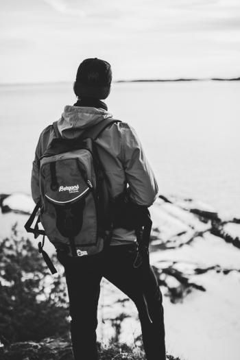 Grayscale Photo of Man Wearing Windsor and Backpack
