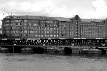 Grayscale Photo of Mid Rise Building Near Body of Water at Daytime
