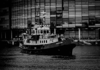 Grayscale Photo of Ship Near Building