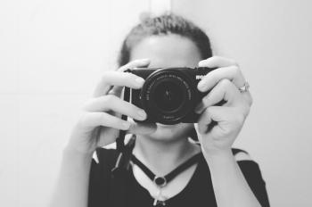 Grayscale Photo of Woman Holding Dslr Camera