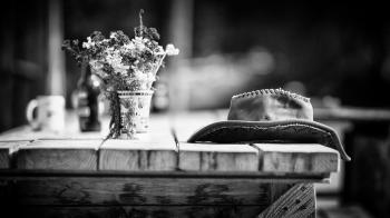 Grayscale Photography of Hat on Wooden Table