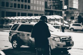 Grayscale Photography of Man Standing Near Suv during Daytime