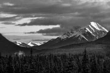 Grayscale Photography Of Snow Covered Mountain Under Cloudy Sky