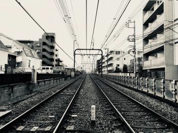 Grayscale Photography of Train Rail Between Buildings