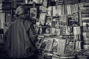 Grayscale Photography of Woman Looking at the Books
