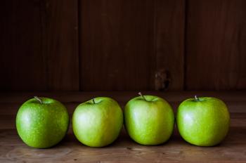 Green apples on a wooden background