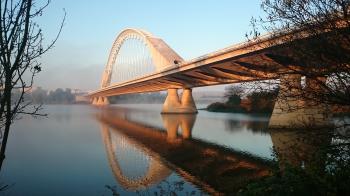Grey Concrete Bridge Above Water Under Blue Sky