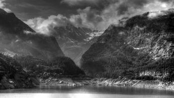 Grey Scale Photo of Body of Water Near Mountain Ranges