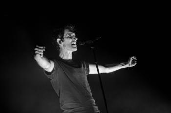 Greyscale Photo of Man Singing