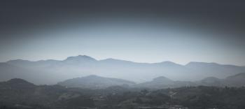 Greyscale Photo of Mountains With Mist