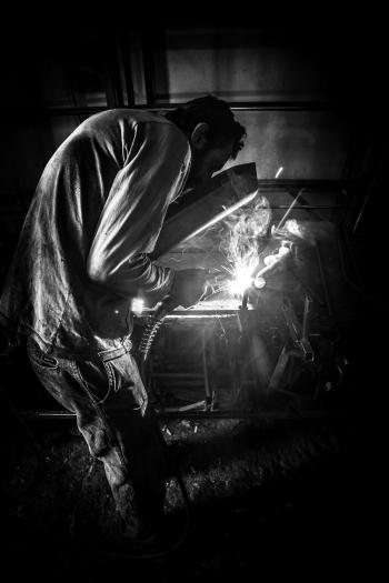 Greyscale Photo of Person Having Welding