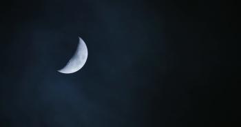 Waxing crescent half moon moving over cloudy night sky background ...