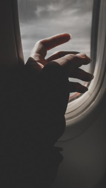 Hand By Airplane Window