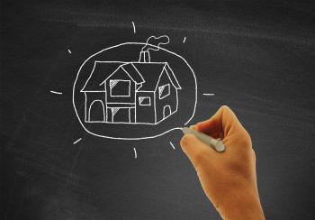 Hand drawing a house on blackboard - Real estate and housing concept