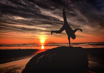 Handstanding on the beach at sunset - Youth and vitality