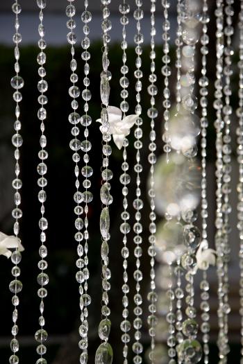 Hanging crystal curtain catches suns rays and moonlight in window ...