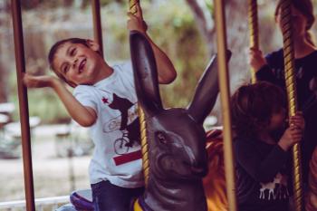 Happy child riding a rabbit carousel