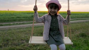 female child swings on tree branch, little Girl riding on swing ...