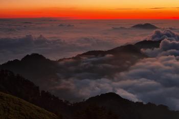 High View Photography of Mountain Ranges Surrounded With Clouds at Golden Hour