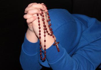 Holding String of Beads - Praying