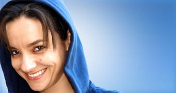 Hooded Young Woman Smiling on Blue Background