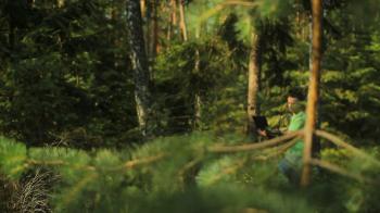 A man walks through the forest with a laptop and looking map He ...