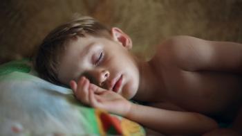 Little boy sleeping, in the dream his face muscles and body twitches ...