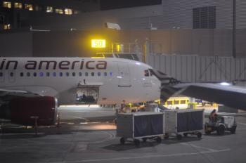 Loading baggage on plane at night