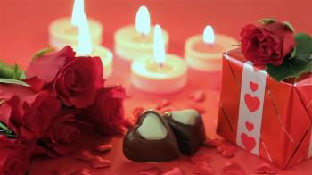 Red roses and chocolate candies with candles for Valentine's Day ...