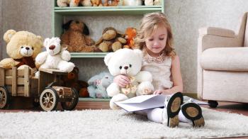 cute little girl reading a book with a teddy bear, play, have fun ...