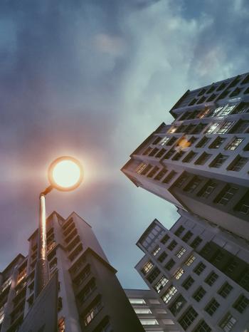 Low Angle Photography of Lamp Post Beside Building Under Cloudy Sky