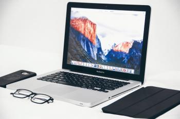 Macbook Air Beside Eyeglasses and Black Smart Case