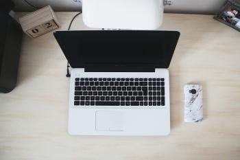 Macbook Beside Smartphone on Desk