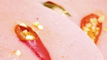 Sliced layers of salami with spicy paprika inside. Macro view at ...