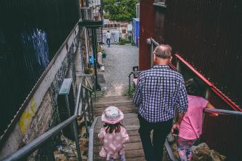 Man and Two Girls Walking Down on Stairs