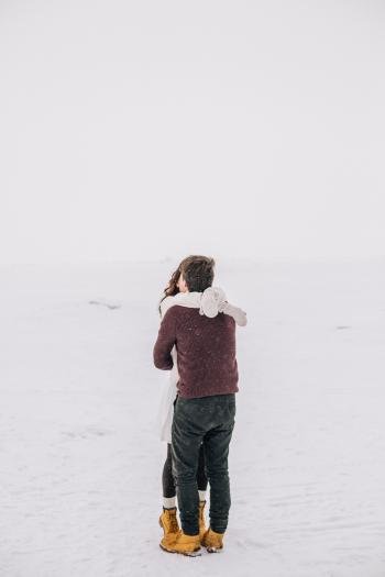 Man and Woman Kissing on Snow Field