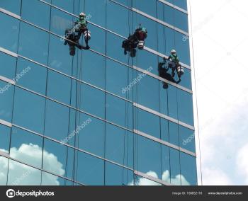 Man Cleaning the Glass of Building