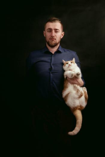 Man in Grey Dress Shirt Holding White and Orange Fur Cat