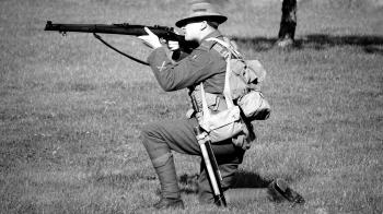 Man in Military Suit Aiming Rifle