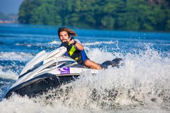 Man in Safety Vest Riding a Personal Watercraft during Daytime