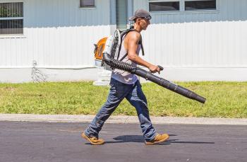 Man in White Tank Top and Blue Denim Pants With Leaf Blower Outdoors during Daytime