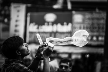 Man Playing Bubbles Grayscale Photo